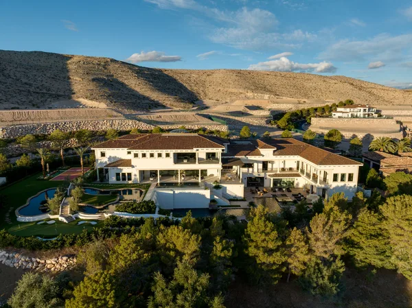 Aerial estate exterior and landscaped rear terraces in La Quinta