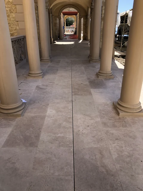 After concealed slot drain in travertine arcade paving