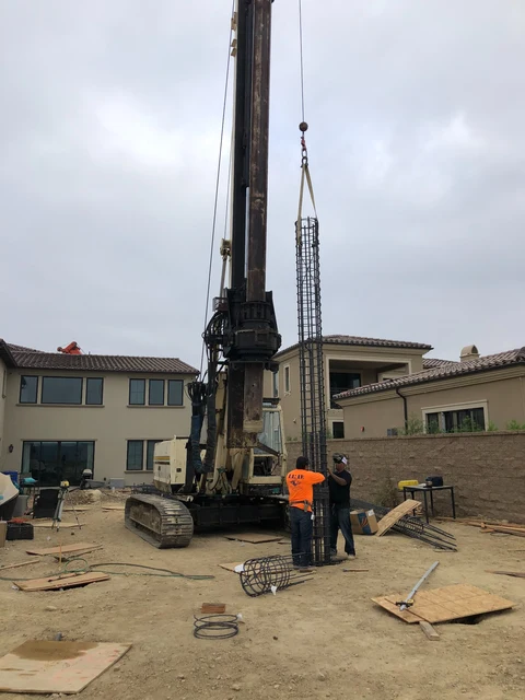 Caisson reinforcing cage suspended beside drilling rig