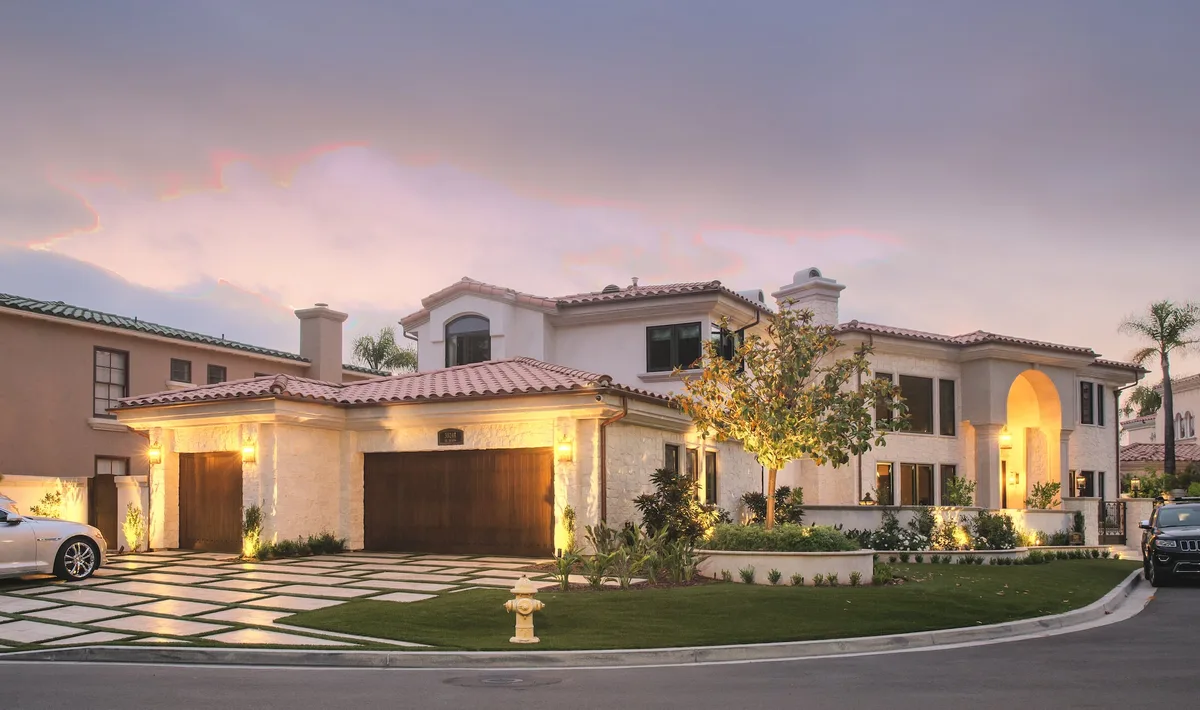Corner residence and landscaped driveway at sunset