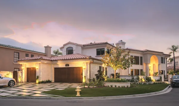 Corner residence and landscaped driveway at sunset