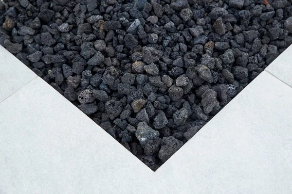 Dark lava rock within pale stone fire pit