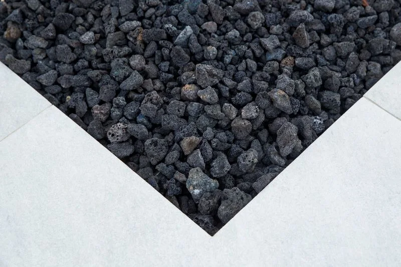 Dark lava rock within pale stone fire pit