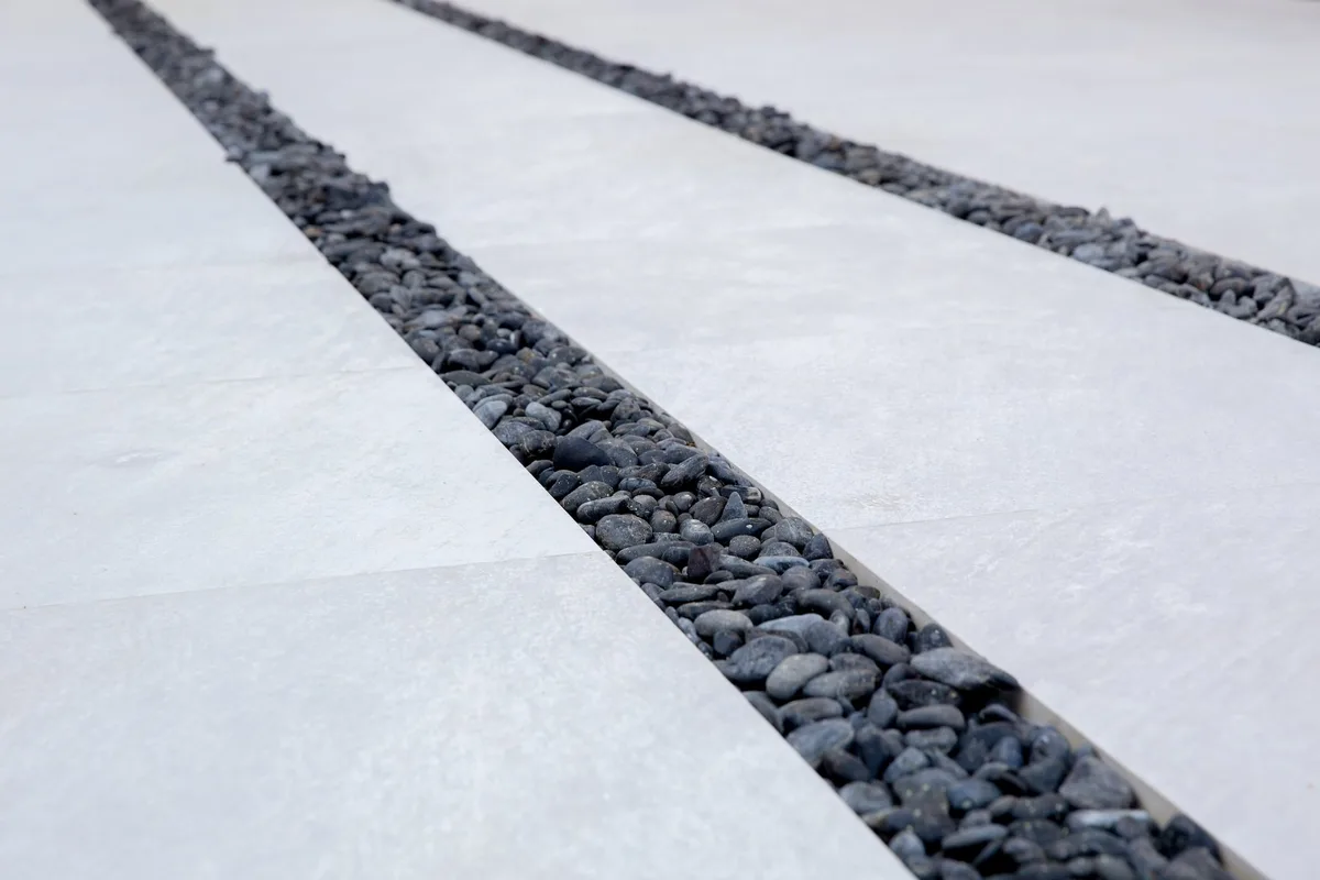 Dark pebble joints between pale paving slabs