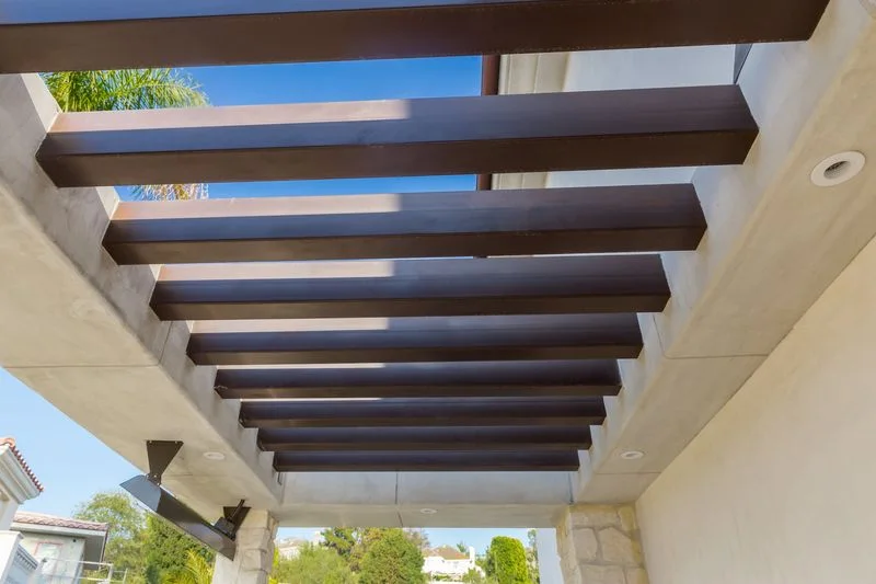 Dark pergola beams against blue sky