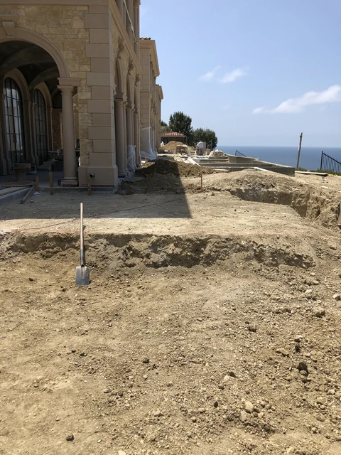 Exterior excavation beside coastal stone residence