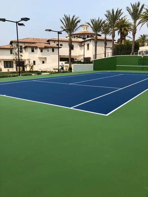 Finished blue tennis court and practice wall