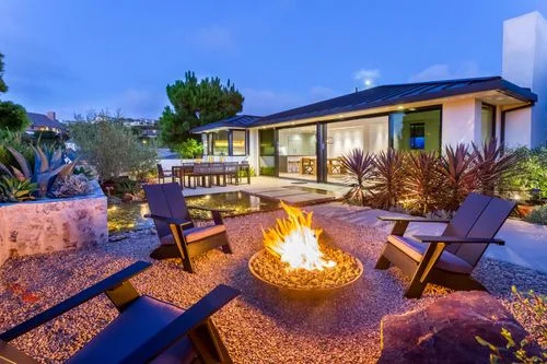 Garden fire bowl and modern residence at dusk