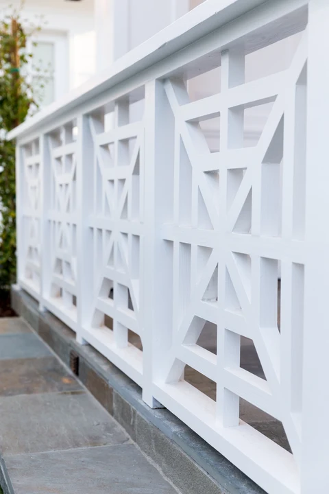 Geometric white railing beside pool house paving