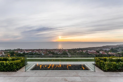 Glass enclosed linear fire pit overlooking ocean horizon