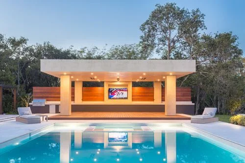 Illuminated pool pavilion reflected in blue water