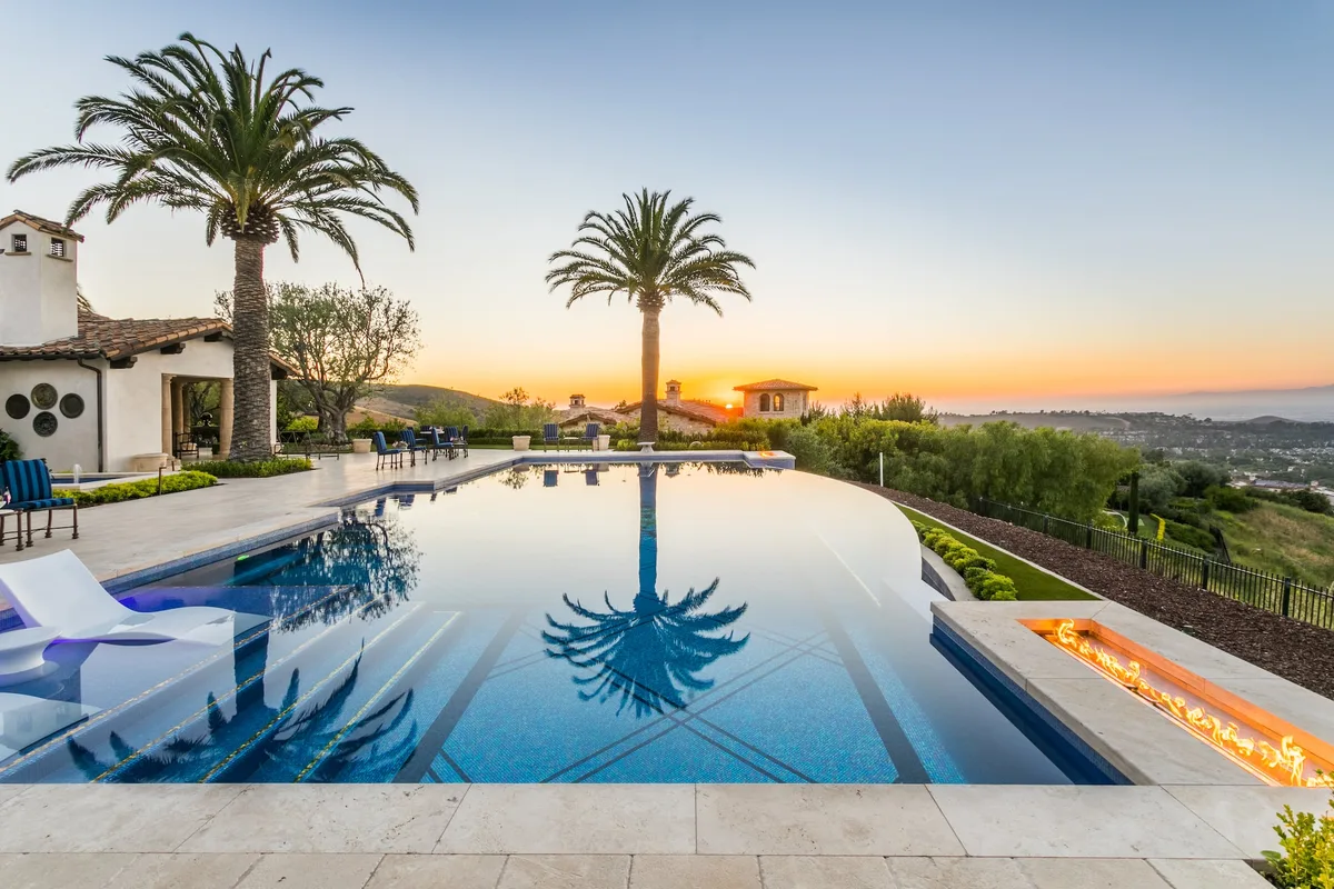 Infinity pool sun shelf and coastal sunset in Irvine