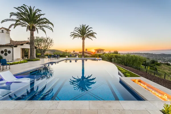 Infinity pool sun shelf and coastal sunset in Irvine