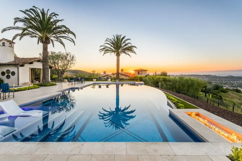 Infinity pool sun shelf and coastal sunset in Irvine