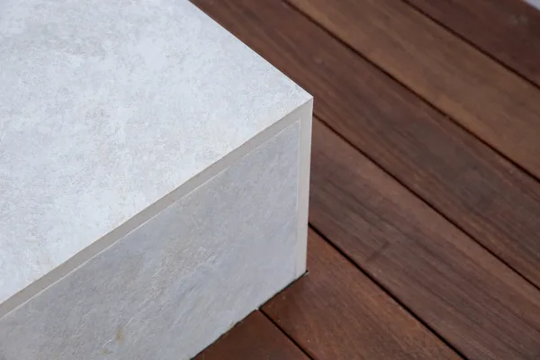 Mitered white stone corner beside wood decking