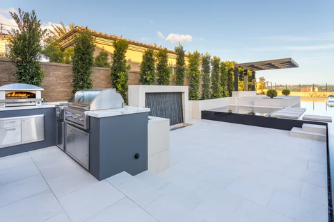 Outdoor grill and pizza oven beside modern pool terrace