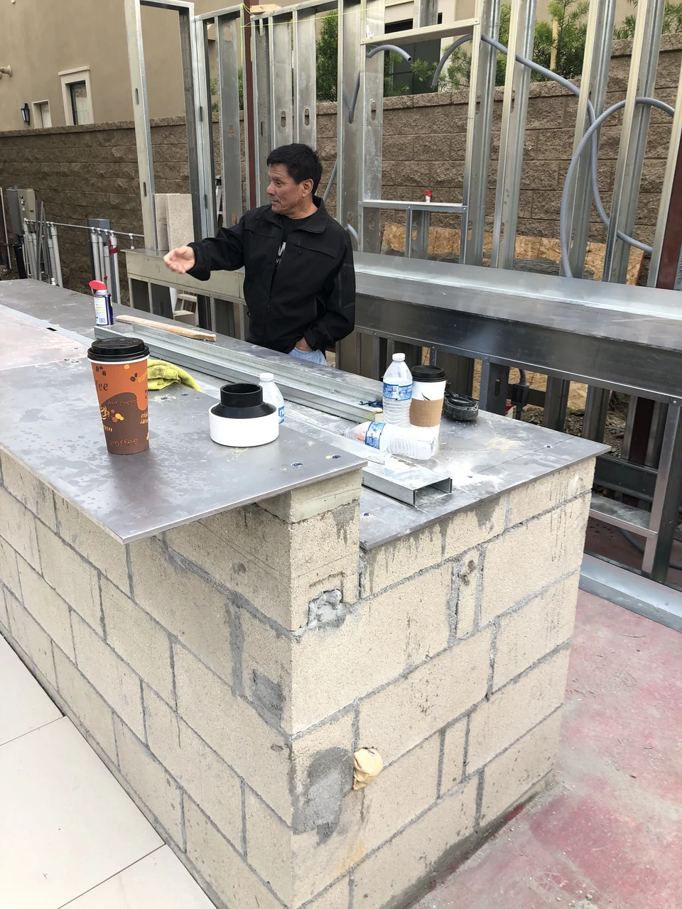 Outdoor kitchen construction with block masonry, metal framing and unfinished counters