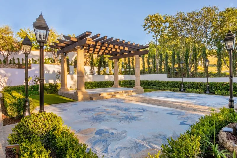 Patterned courtyard paving framed by pergola and hedges in Irvine