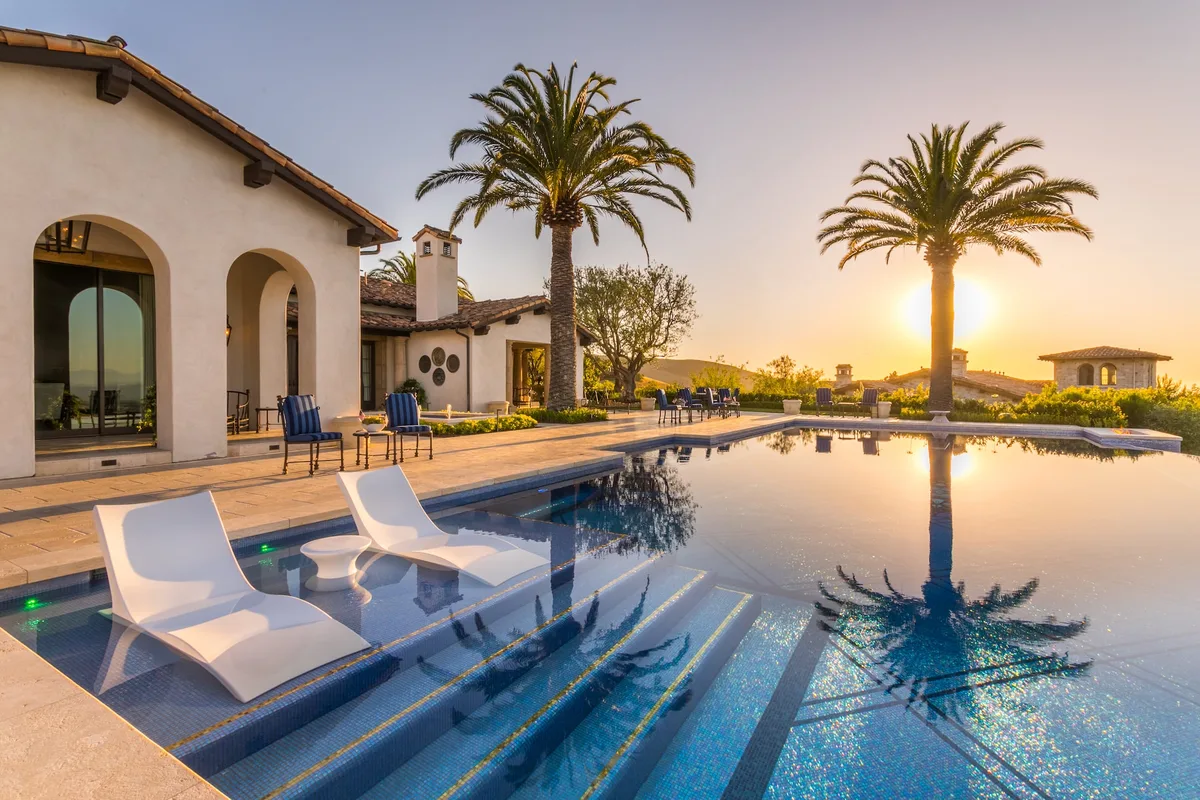Pool sun shelf with white loungers at sunset in Irvine