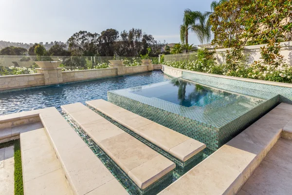 Raised green tiled spa with wide stone steps
