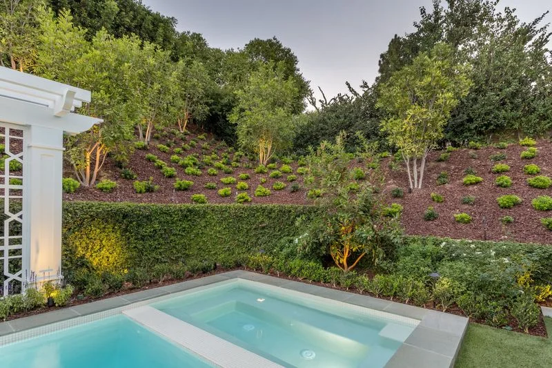 Raised spa with planted slope and clipped hedge