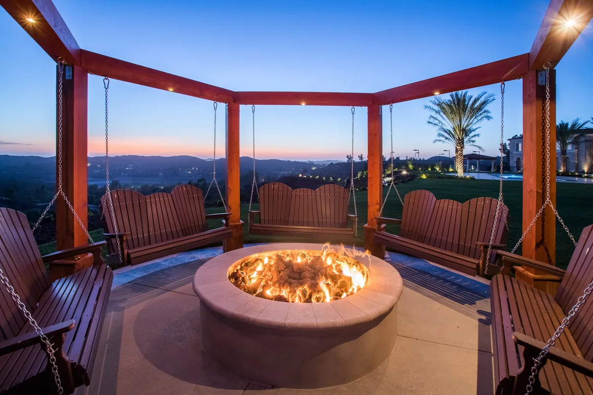 Round fire pit with hanging swings at dusk in Coto de Caza