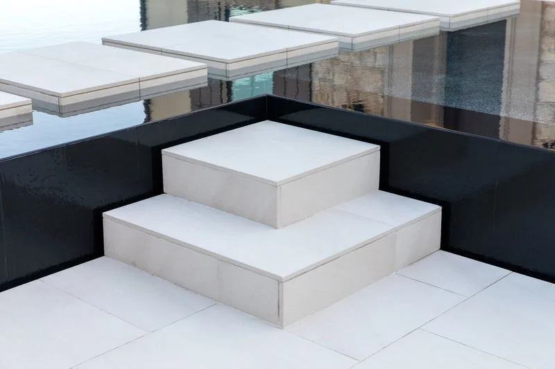 Square tiled spa steps and black pool edge