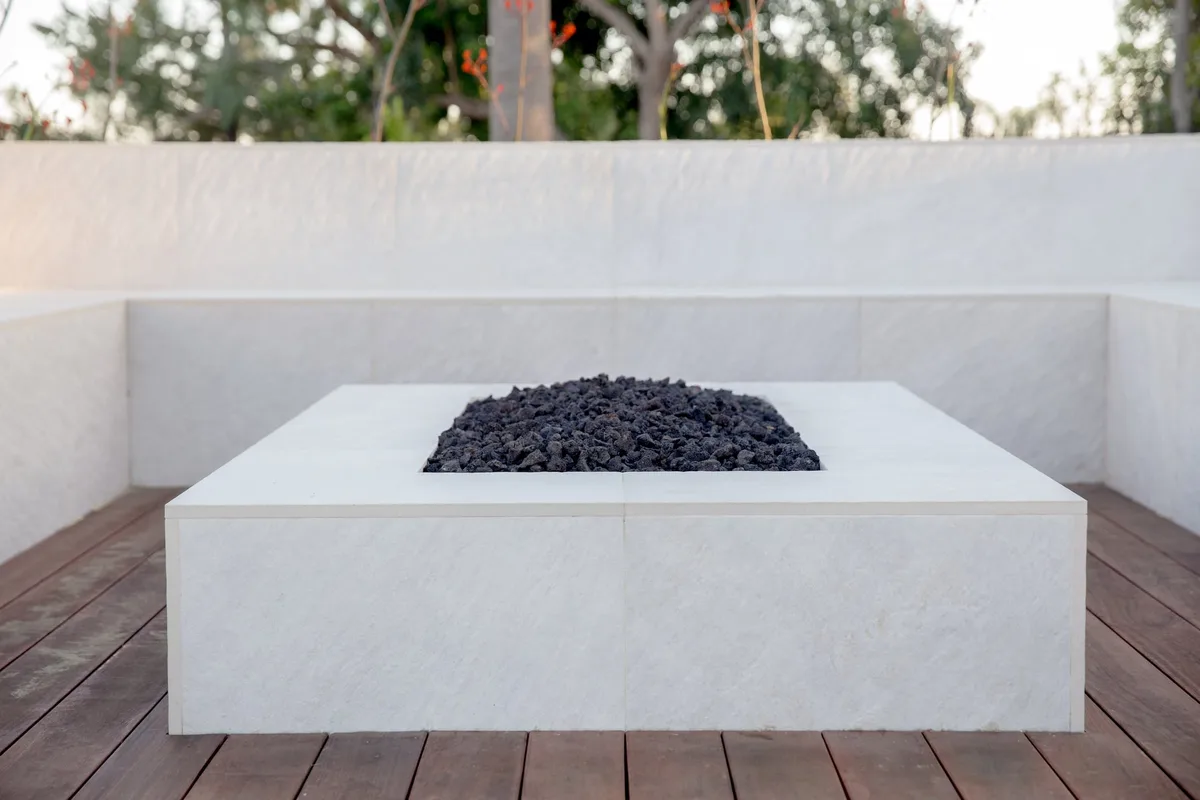 Square white fire pit and built in corner seating