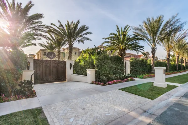 Stone driveway and gated entry with palms in Crystal Cove