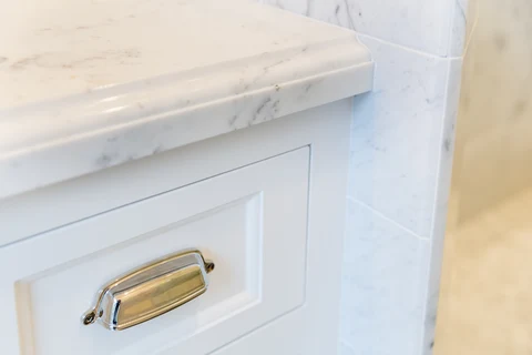 Stone vanity counter edge and cabinet pull detail