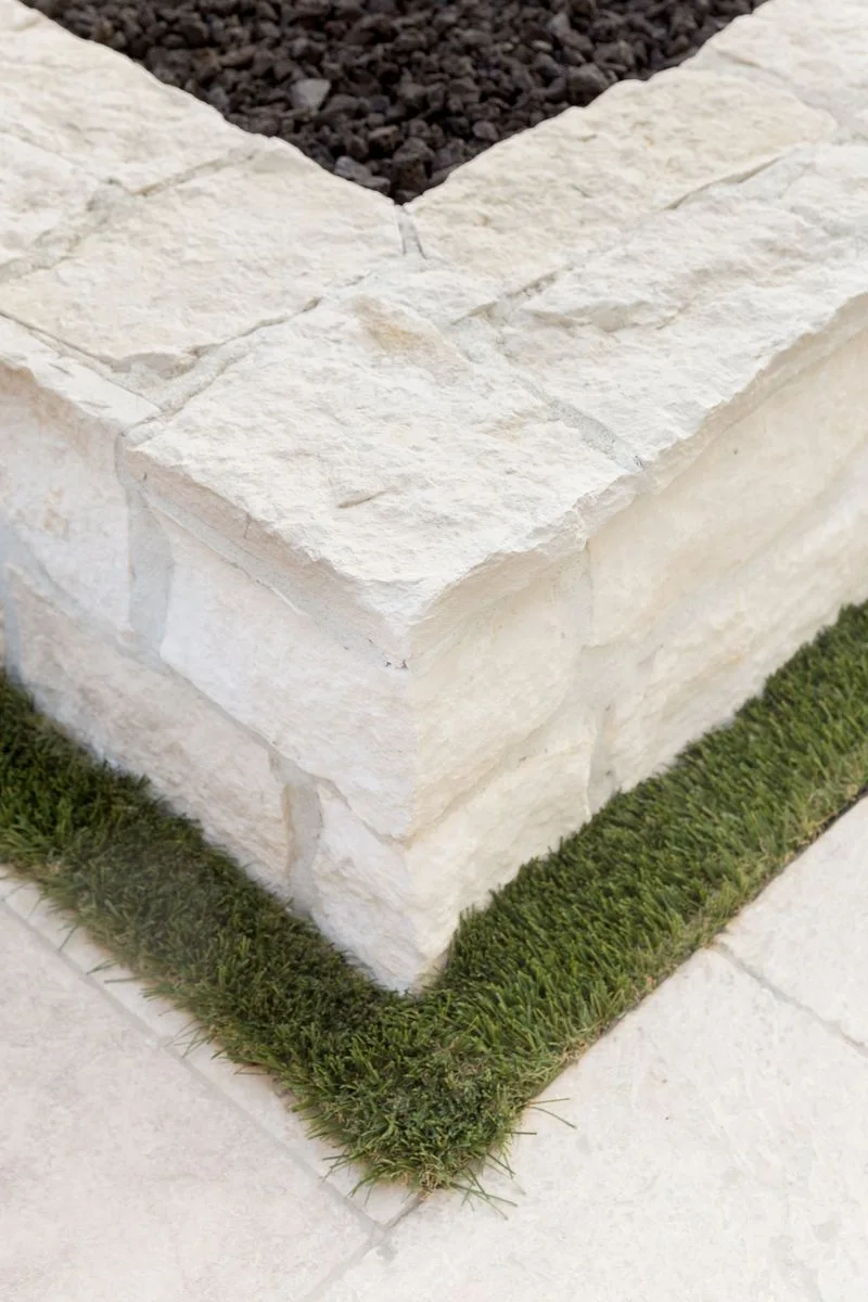 Textured stone fire pit corner and grass border