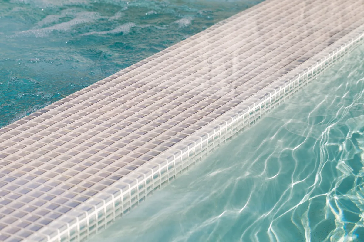 White mosaic tiled spa spillway with flowing water