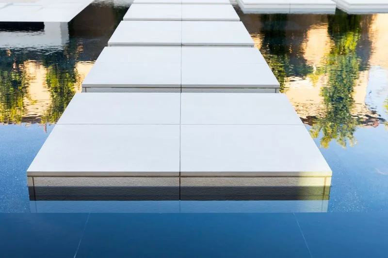 White stepping pad detail above reflective water