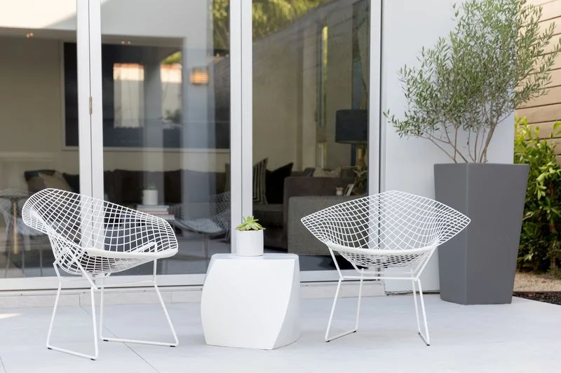White wire patio chairs and sculptural side table