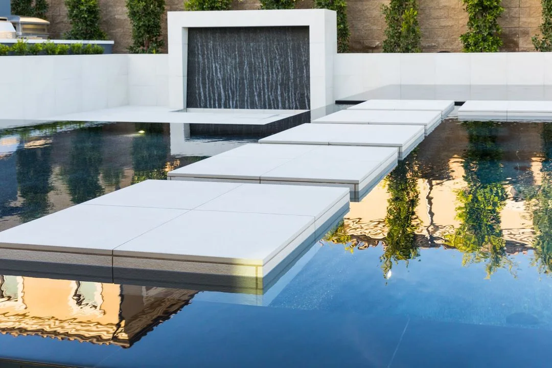 Stepping pads across a reflecting pool toward a water wall