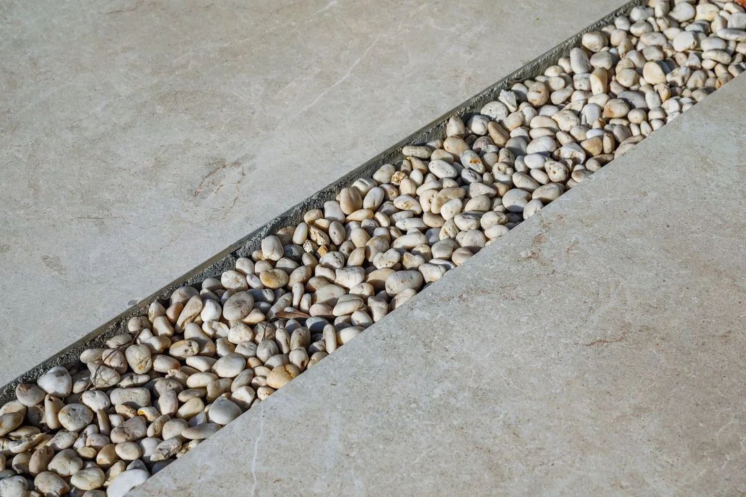 Pale paving slabs separated by a decorative gravel joint