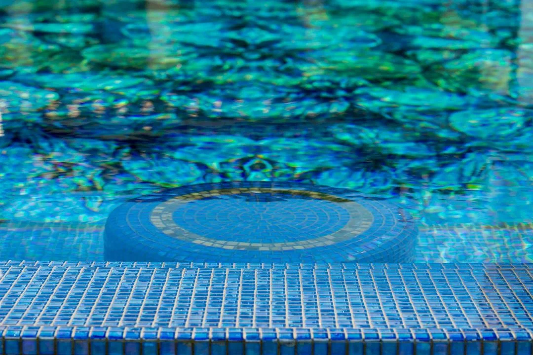 Blue mosaic tile detail beneath pool water