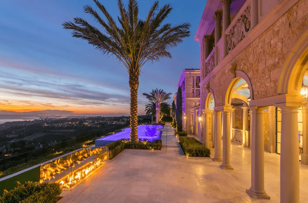 Illuminated coastal terrace with palms and an ocean view at a Crystal Cove home