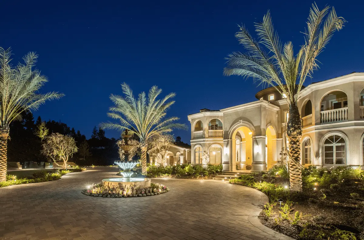 Illuminated estate entrance, palms and fountain in a Laguna Beach landscape
