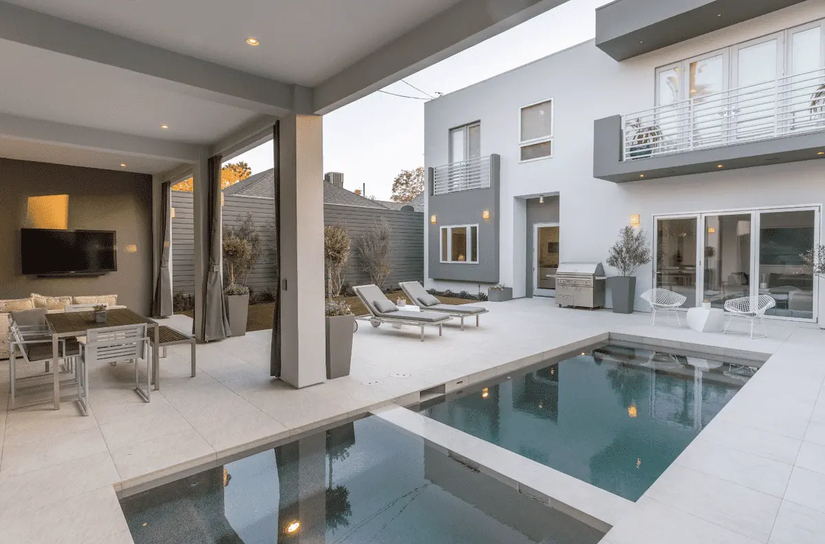 Compact modern pool and spa beside a covered outdoor living room