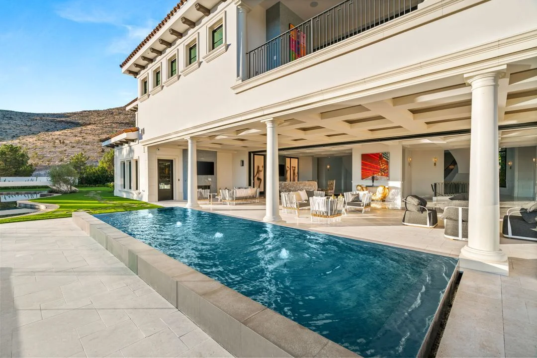 Long swimming pool beside a covered outdoor living room